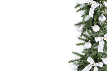 Christmas fir tree branches with baubles and bows on white background