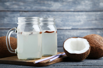 Fototapeta na wymiar Coconut water in jars with straws on wooden table