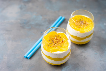 Mango smoothie with yogurt and nuts in two glasses