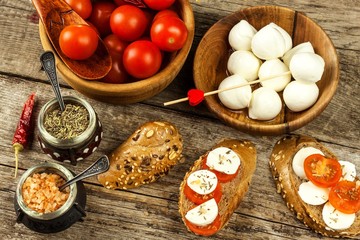 Traditional Italian Mozzarella cheese on a wooden board. Healthy cheese. Dairy products. Mozzarella cheese balls with  tomatoes. Diet food.