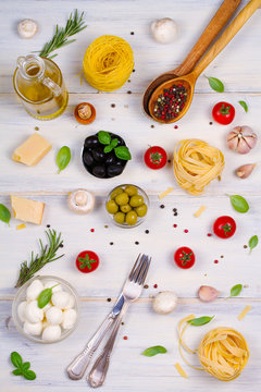 Italian food or ingredients with fresh vegetables, pasta, cheese mozzarella and parmesan, spices. Healthy food background. View from above, top studio shot