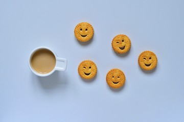 Cup of coffee and cheerful cookies on a light background 