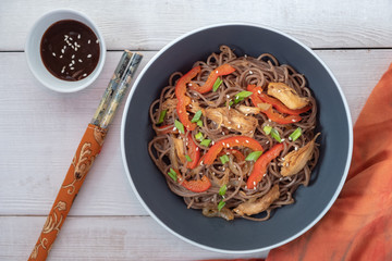 Dark pasta with steamed vegetables and grilled chicken. Delicious buckwheat noodles with vegetables...