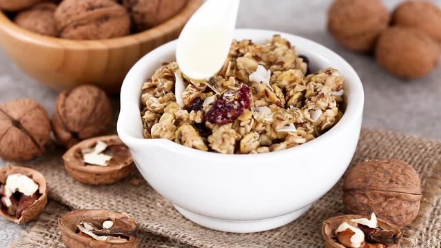 Bowl of homemade granola with nuts and honey. Horizontal view