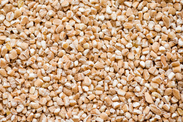 Crushed Spelt wheat, raw spelt porridge, top view, abstract background for your design
