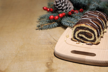 Makowiec świąteczny z bakaliami i w polewie czekoladowej na drewnianej desce, Boże Narodzenie,...