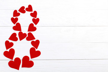 Red hearts on a white background in the form of eight. Concept women's day. Place for text, copy space.