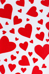 Fototapeta na wymiar Red hearts of different sizes on a white background. Harvesting cards for Valentine's Day.