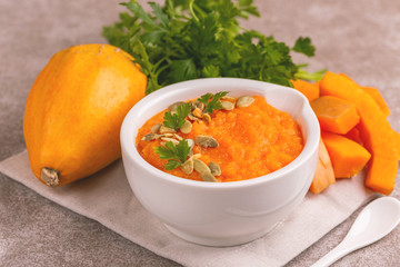 Bright tasty pureed pumpkin soup with ingredients