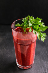 Fresh bright beetroot smoothie in glass with sprig of parsley