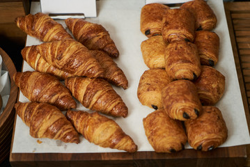 Plain croissant and chocolate puff pastry buns, on restaurant bu