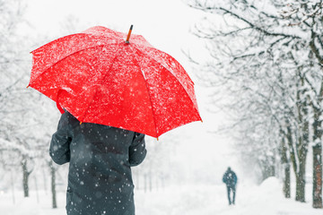 Woman with red umbrella in snow