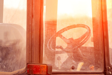 through the cab of the tractor, the sun is shining, the steering wheel in the cabin, sunset,...