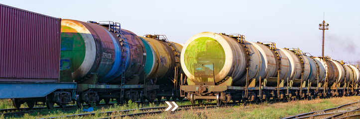 Fototapeta na wymiar Transportation of oil tanks at sunset, transportation by rail