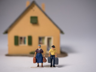Senioren mit Koffern vor Privathaus 