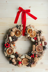 Christmas card. Background Christmas and new year. Christmas wreath of nuts, cones, dried oranges, corks of champagne, cinnamon sticks, ribbons. Christmas in a rustic style. Handmade decor. Christmas 