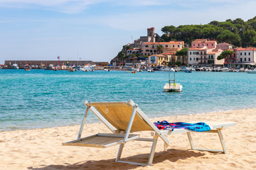 MARINA DI CAMPO, ISOLA ELBA, ITALY - SEPTEMBER 16, 2018: Beach of the town Marina di Campo end emerald sea of Elba Island. Tuscany, Italy.