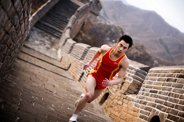 Teenage boy running along the Great Wall of China.