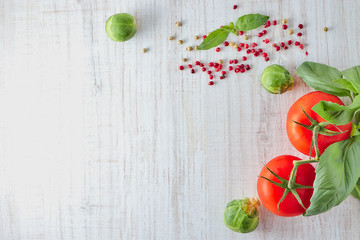 Fresh red tomatoes with a bunch of Basil and Savoy cabbage on a wooden table. copy space. the view from the top. natural product.