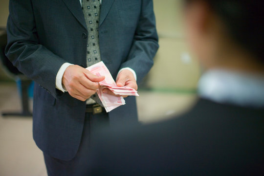 Man's hands counting a stack of dollar bills.