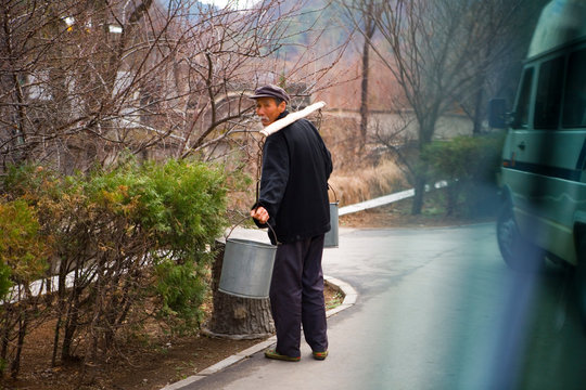 Man carrying large buckets of water.