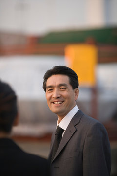 Mid-adult businessman standing on a wharf.