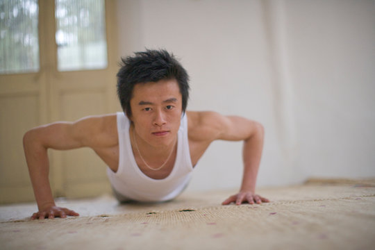 Portrait of a teenage boy about to do a press-up.