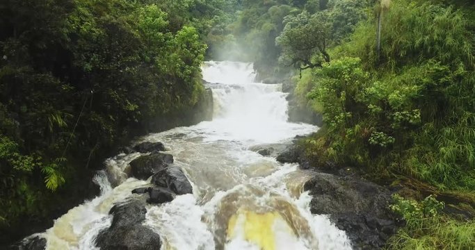 Aerial shot following river upstream to waterfall