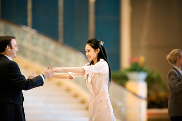 Young adult couple dancing in a hotel lobby.