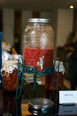 Tomato juice jar with tap. Fresh tomato juice in glass jar on Ho