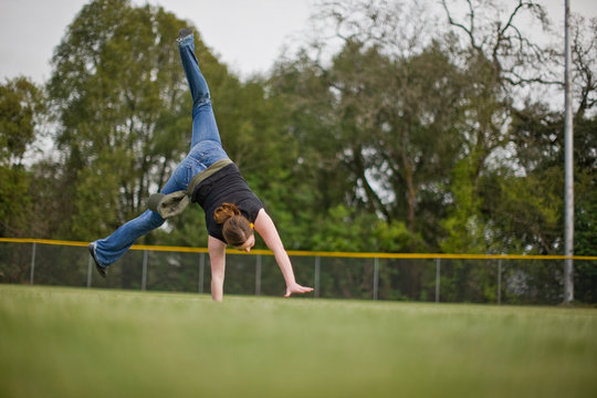 Woman doing cartwheels on sport field