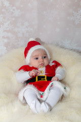 baby in santa claus hat sitting on white background