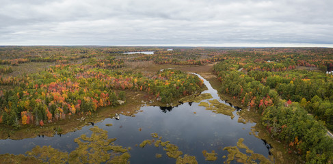 Aerial panoramic view of a beautiful lake during a cloudy autumn day. Taken in Lily Lake, near Annapolis, Nova Scotia, Canada.