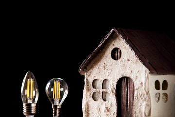 Led lamps near the house layout on a black background 
