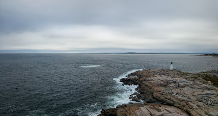 Fototapeta na wymiar Aerial panoramic view of a Lighthouse on a rocky coast of the Atlantic Ocean. Taken in Peggy Cove, near Halifax, Nova Scotia, Canada.