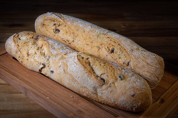 Baking bread, flour products.Baguette on dark wooden background