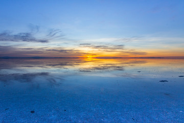 Fototapeta na wymiar Uyuni reflections. One of the most amazing things that a photographer can see. Here we can see how the sunrise over an infinite horizon with the Uyuni salt flats making a wonderful mirror to infinity