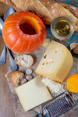 Ingrediens for traditional seasonal Swiss dish, pumpkin fondue with gruyer and emmentaler cheeses,...