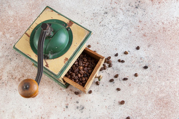 Old wooden coffee grinder on concrete background.