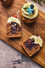 Handmade capcake with blueberries on wood background top view.