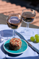 Rose wine of Provence, France, served cold with soft goat cheese on outdoor terrace in two wine glasses