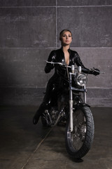 Obraz na płótnie Canvas Sexy biker girl in a latex on a motorcycle