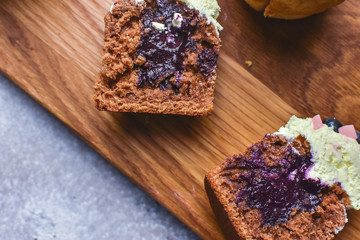 Cutted handmade capcake with blueberries on wood background top view.
