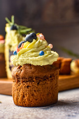 Handmade capcake with blueberries on wood background top view.