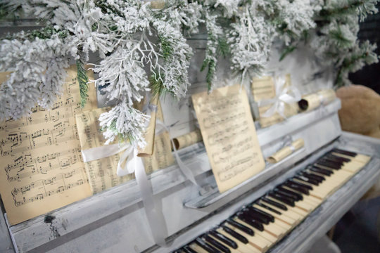 Piano under the christmas tree branches and notes