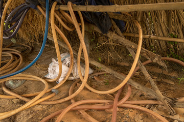 Vintage Old Hosepipe on Dirty Concrete Ground with Straw - Messy Abandoned Chicken Coop