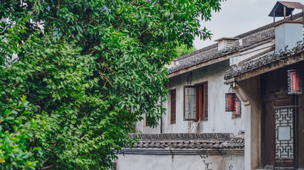 Traditional white wall black roof Chinese house by green trees, in Hangzhou, China