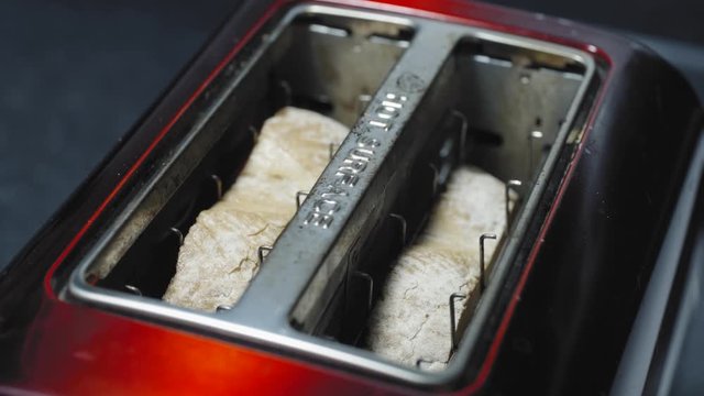 Prepareing toast in a home kitchen. Good quality bread and good quality butter. Cinematic lighting with suttle grading.