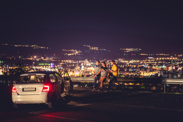 Friends standing at the highway at night