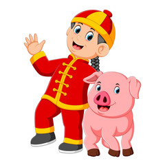a little boy Is playing with a big pink pig in the chinese new year 